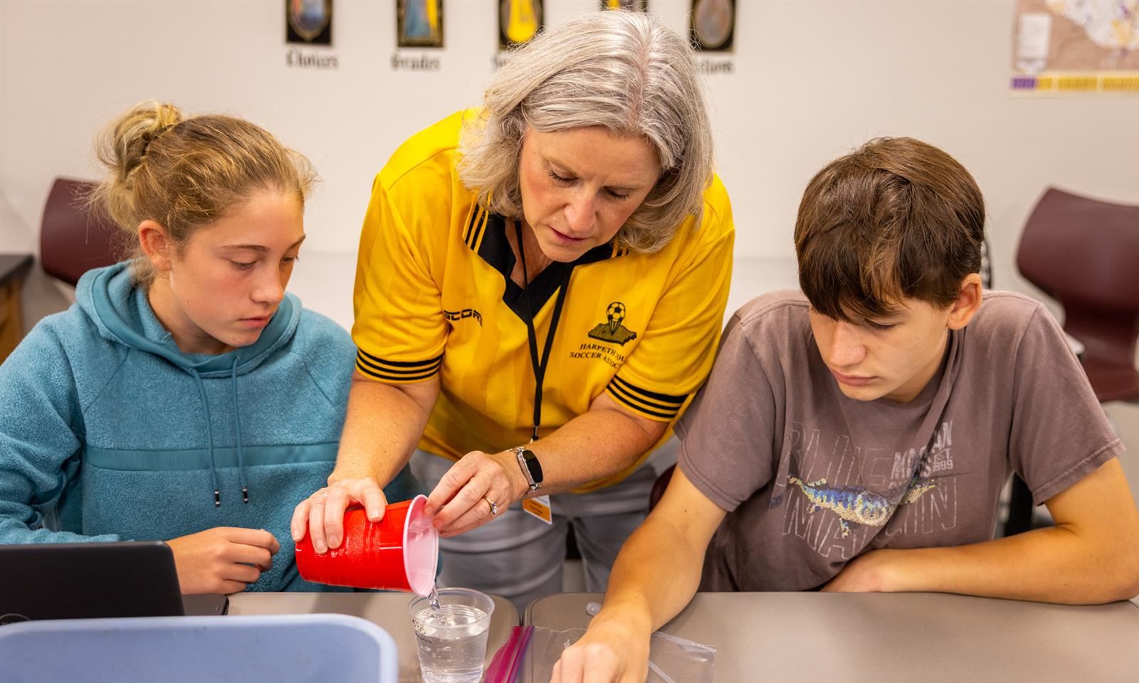 A teacher helps students with a science lab